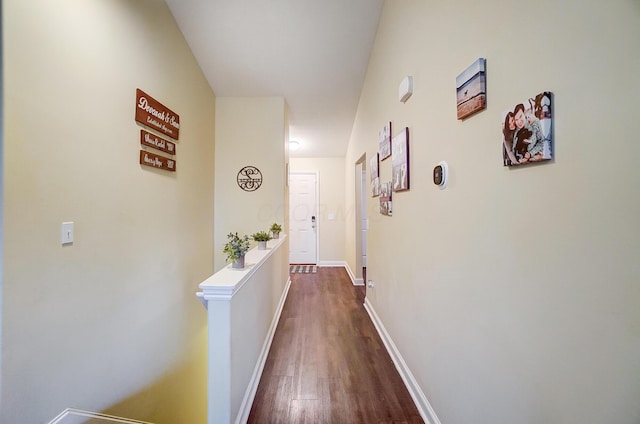 hallway with dark wood finished floors and baseboards