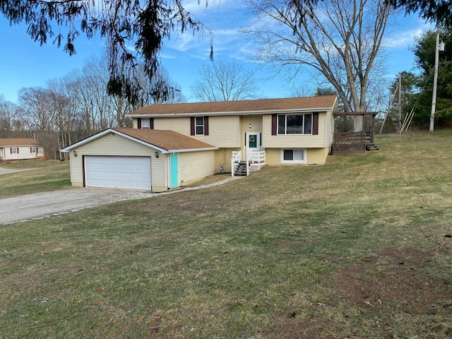 raised ranch featuring driveway, an attached garage, a front yard, and entry steps