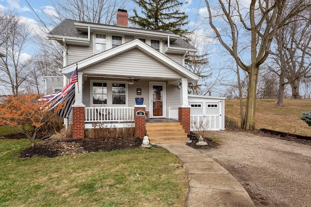 traditional style home with a chimney, aphalt driveway, roof with shingles, an attached garage, and a porch