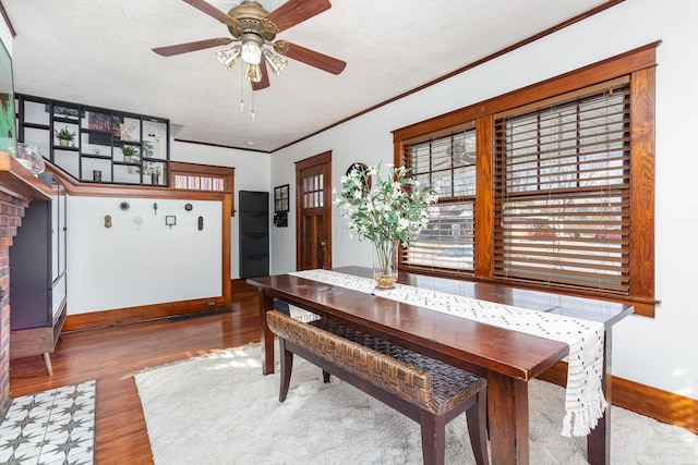 dining space featuring crown molding, a textured ceiling, and wood finished floors