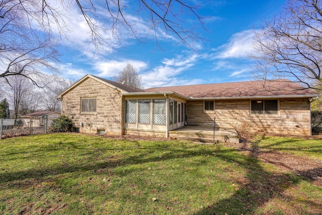 back of house with a sunroom, stone siding, fence, and a lawn