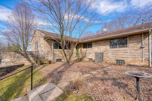 view of front of house featuring stone siding and fence