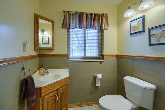 bathroom featuring wainscoting, vanity, and toilet