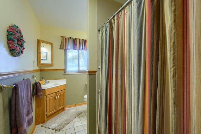 bathroom with lofted ceiling, tile patterned flooring, toilet, a shower with shower curtain, and vanity