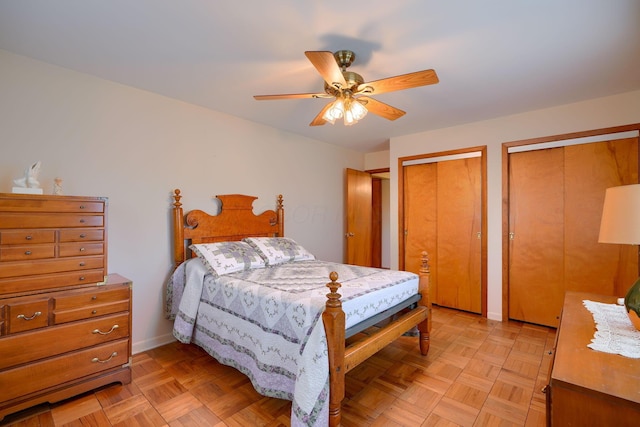 bedroom with a ceiling fan and two closets