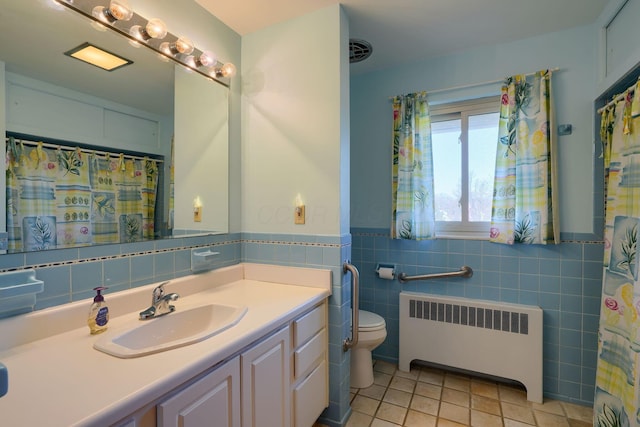full bath with wainscoting, toilet, radiator heating unit, tile patterned floors, and vanity