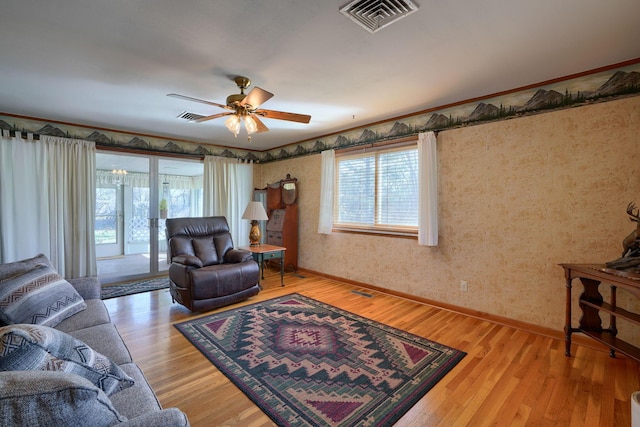 living room with light wood-type flooring, a healthy amount of sunlight, and visible vents