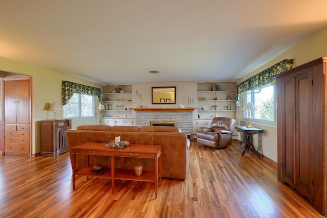 living area with plenty of natural light, light wood-style flooring, and a fireplace