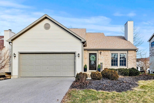 single story home featuring aphalt driveway, a garage, a shingled roof, brick siding, and a chimney