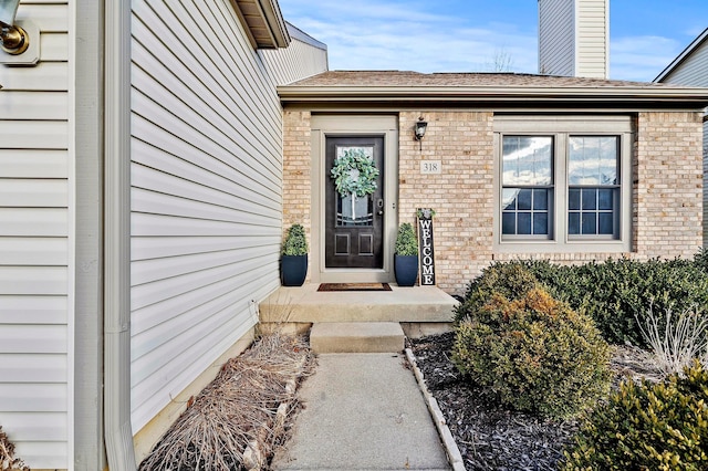 view of exterior entry with brick siding