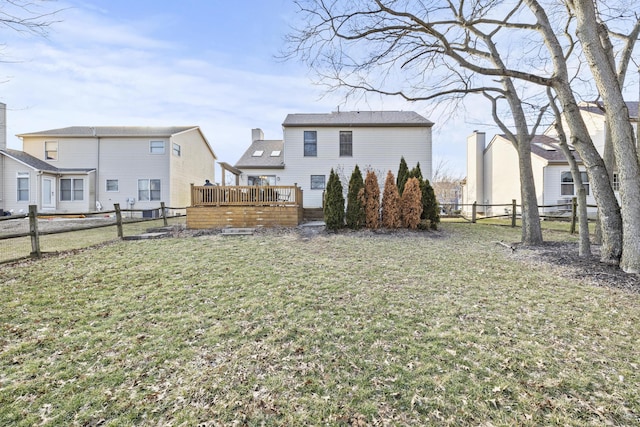 rear view of property featuring a fenced backyard, a deck, and a yard