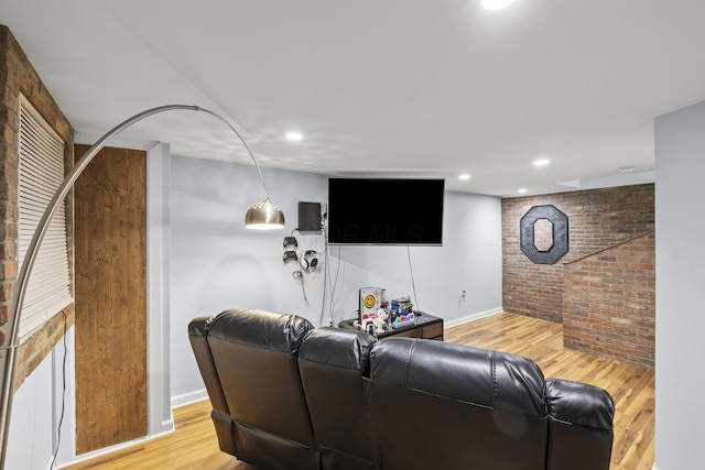 living area with baseboards, brick wall, light wood-style flooring, and recessed lighting