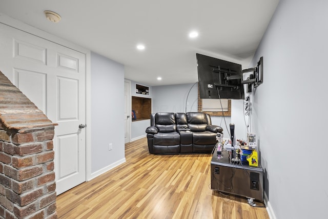 living area with baseboards, wood finished floors, and recessed lighting