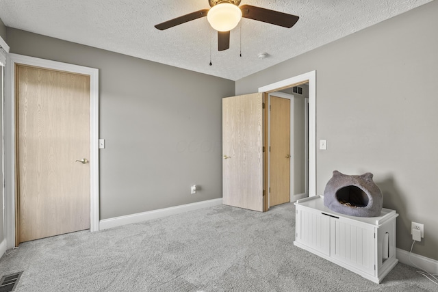 unfurnished bedroom with carpet floors, baseboards, visible vents, and a textured ceiling