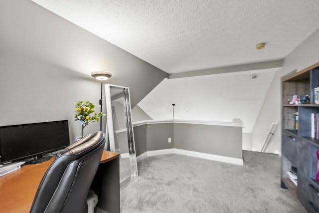 carpeted office featuring a textured ceiling and baseboards