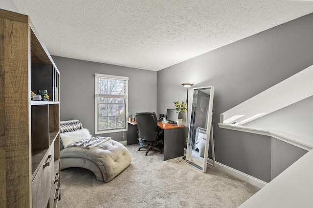 carpeted home office with a textured ceiling and baseboards