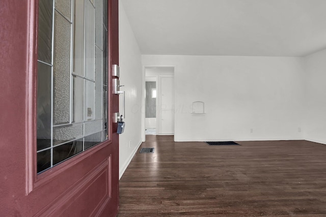 foyer entrance featuring dark wood-style flooring and visible vents