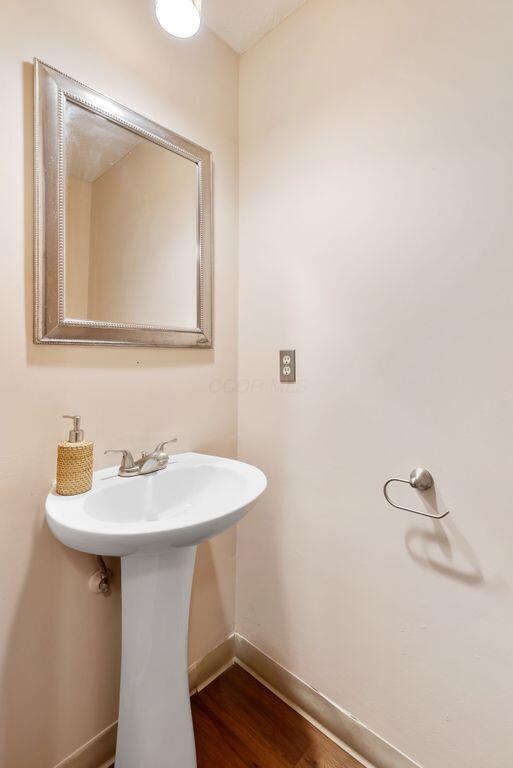 bathroom with wood finished floors and baseboards