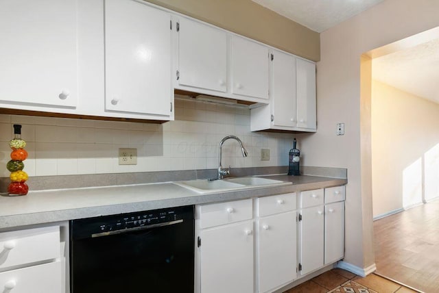 kitchen with tasteful backsplash, white cabinetry, dishwasher, and a sink