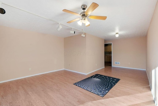 empty room featuring visible vents, ceiling fan, baseboards, and wood finished floors