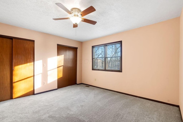 unfurnished bedroom featuring carpet floors, a textured ceiling, and baseboards