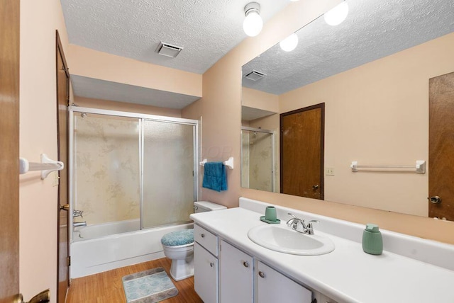 full bath featuring toilet, visible vents, wood finished floors, and vanity