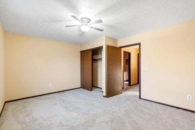 unfurnished bedroom featuring a closet, light colored carpet, a ceiling fan, a textured ceiling, and baseboards