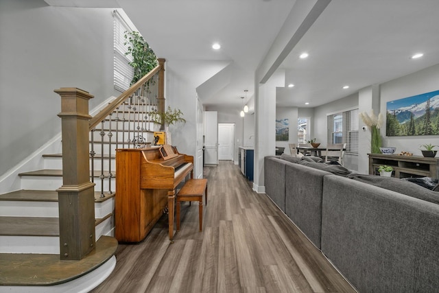 living room featuring recessed lighting, wood finished floors, and stairs