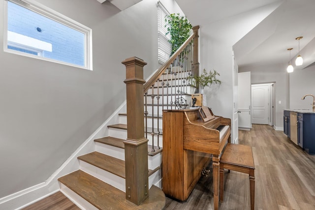 stairs featuring wood finished floors and baseboards