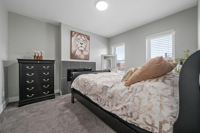 bedroom featuring baseboards, carpet floors, and a fireplace