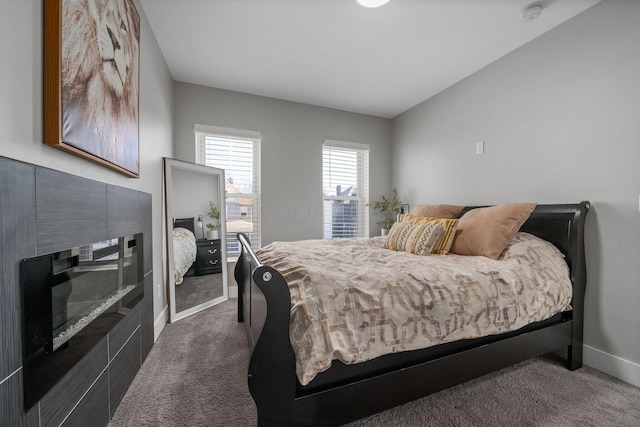 bedroom featuring a fireplace, baseboards, and carpet floors