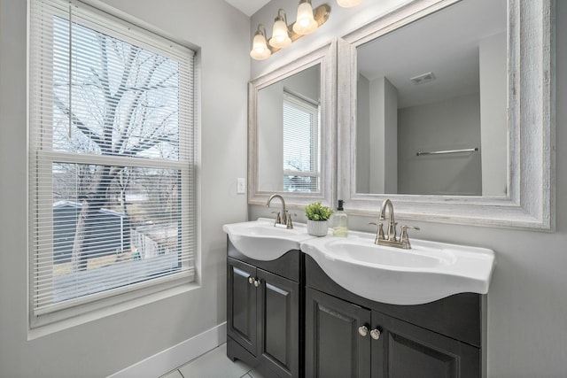 full bath featuring tile patterned flooring, visible vents, baseboards, double vanity, and a sink