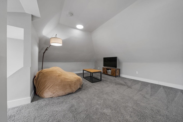 living area with vaulted ceiling, carpet flooring, and baseboards