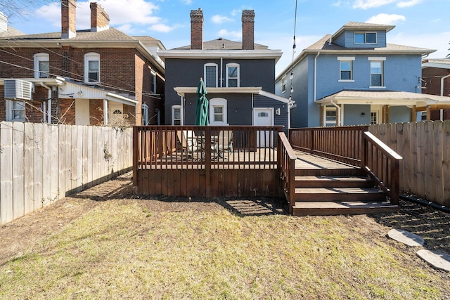 back of house featuring a yard, fence private yard, brick siding, and a wooden deck