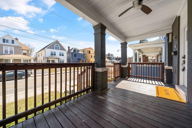 wooden terrace with a residential view and ceiling fan