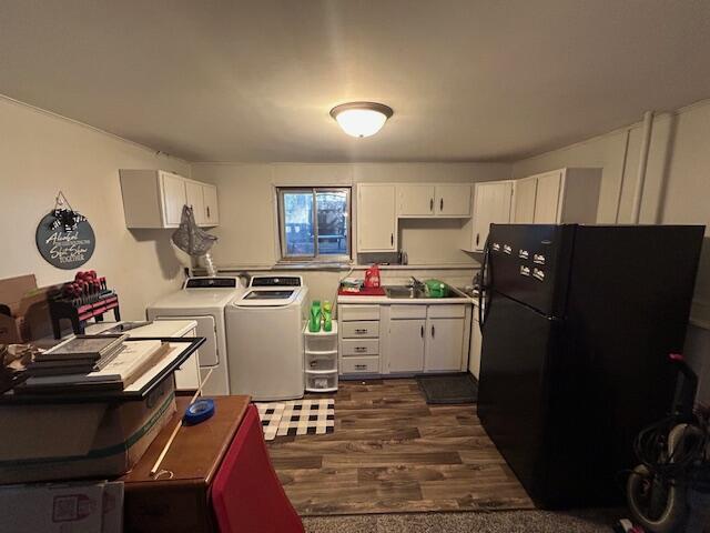 kitchen featuring separate washer and dryer, a sink, freestanding refrigerator, white cabinetry, and dark wood-type flooring