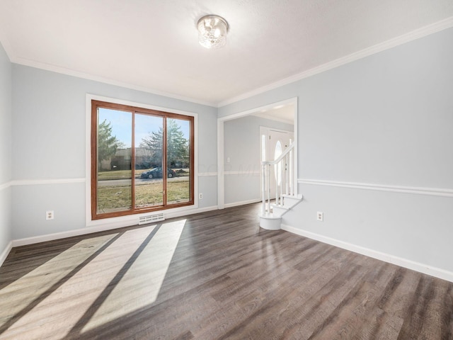 spare room with visible vents, stairway, baseboards, and wood finished floors