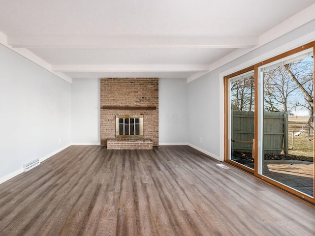 unfurnished living room with baseboards, a fireplace, visible vents, and wood finished floors