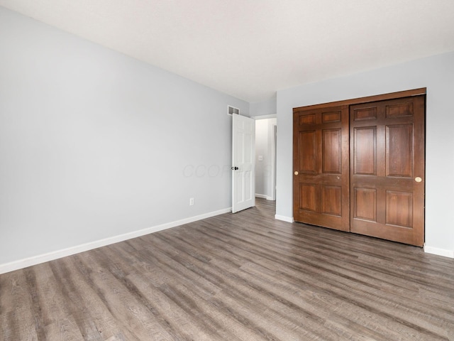 unfurnished bedroom featuring visible vents, baseboards, and wood finished floors