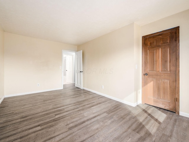 empty room featuring baseboards and wood finished floors