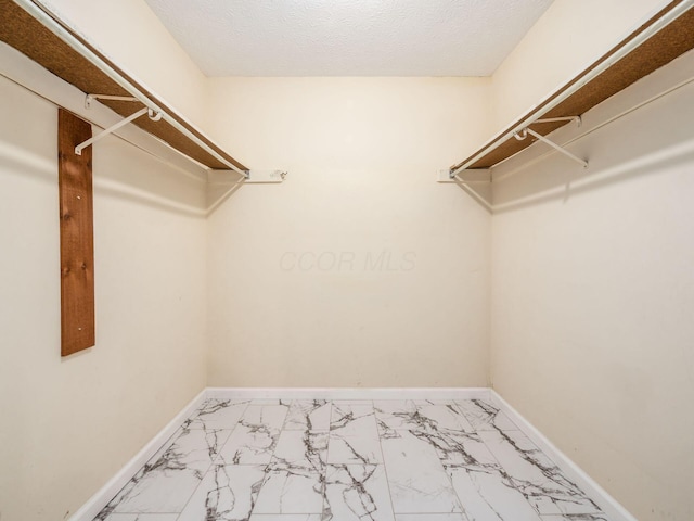 spacious closet featuring marble finish floor