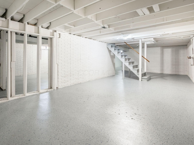 basement with brick wall and stairs