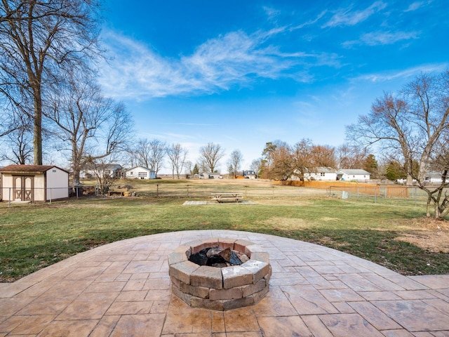 view of patio / terrace with a fire pit, a storage shed, an outdoor structure, and fence