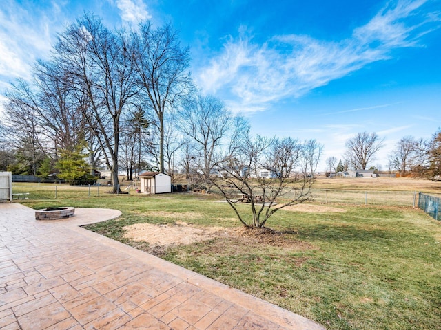 view of yard featuring a shed, fence, a patio, and an outdoor structure