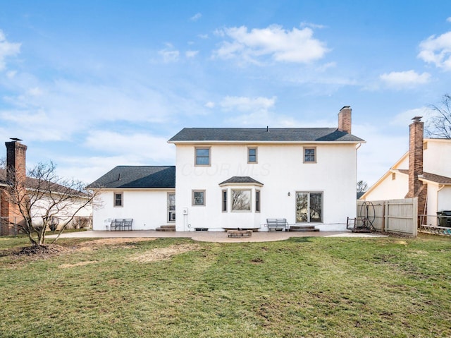 rear view of property with a yard, fence, stucco siding, and a patio