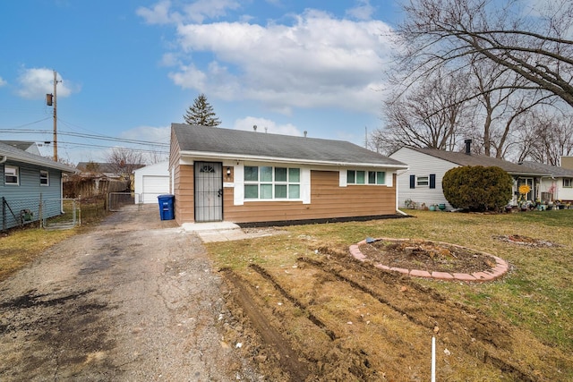 view of front of home with an outbuilding, a front lawn, fence, and a garage