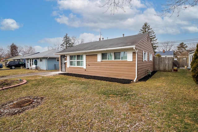 bungalow-style house featuring a front yard, fence, and driveway