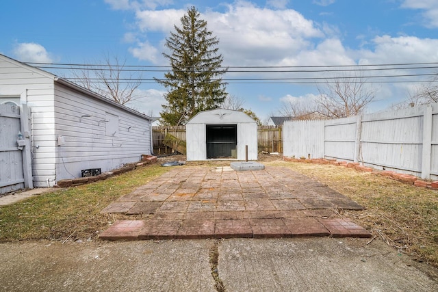 exterior space featuring a fenced backyard, a patio, an outdoor structure, and a storage unit