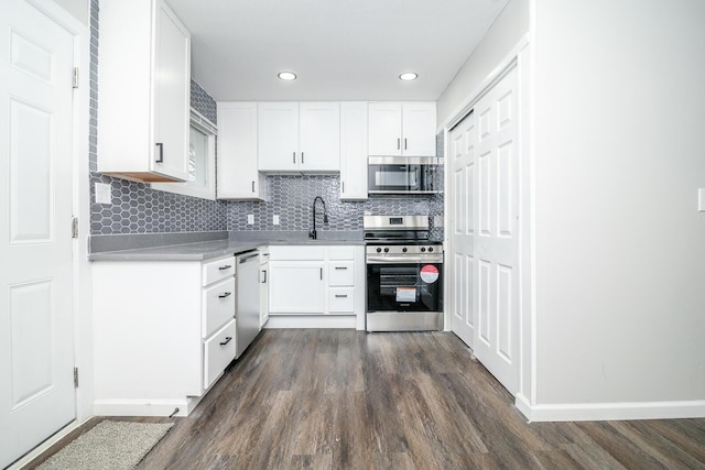 kitchen with dark wood-style floors, tasteful backsplash, white cabinetry, and stainless steel appliances