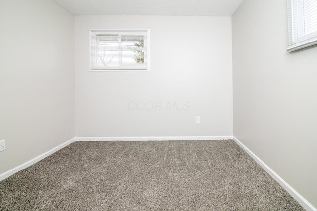 unfurnished room with carpet floors and baseboards